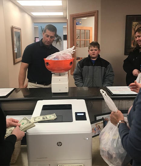 Dentist and child weighing candy donation for troops