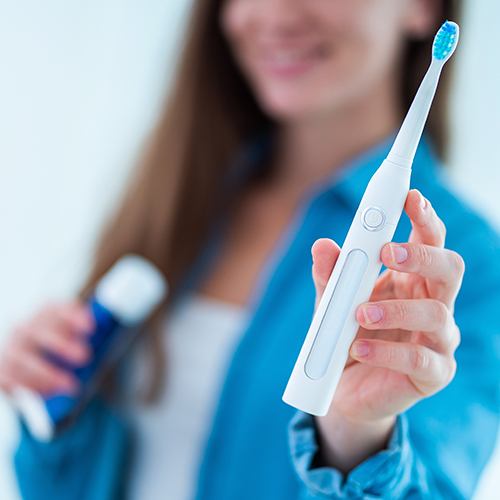 Smiling woman holding up a toothbrush