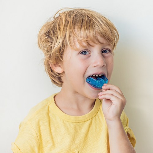 Child placing an athletic mouthguard