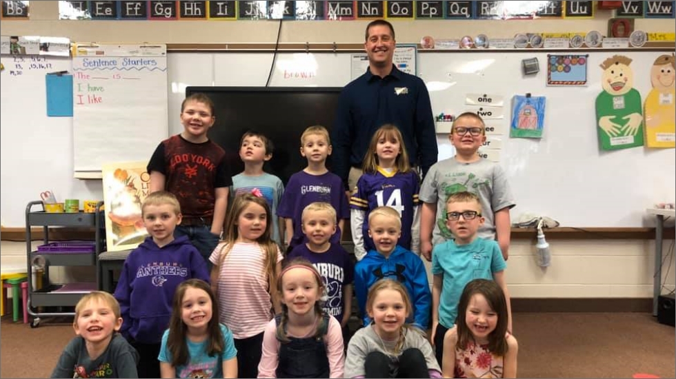 Dentist in classroom with children after dental education event