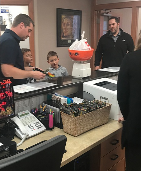 Kids talking to dentist at dental office front desk