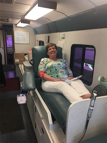 Smiling dental team member giving blood