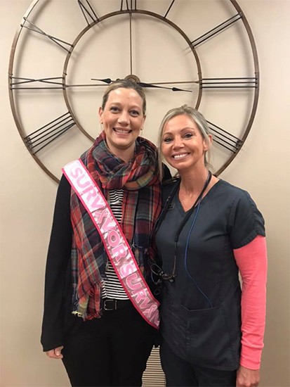 Dental team member and patient smiling together