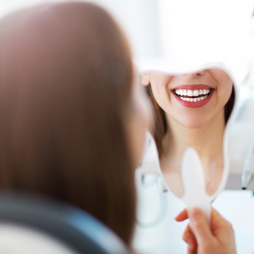 Woman looking at smile after gum recontouring