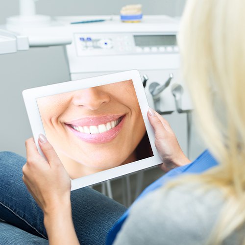 Woman looking at digital smile design on computer screen