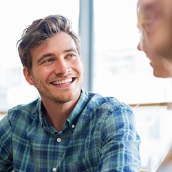 young man smiling while talking to friend 