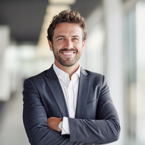 Man in suit smiling with his arms folded