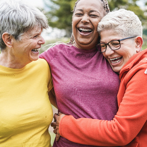 a group of friends smiling and laughing while taking a walk outdoors