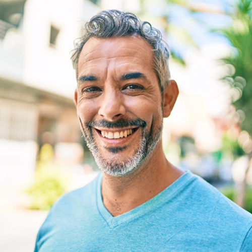 a smiling person standing outside