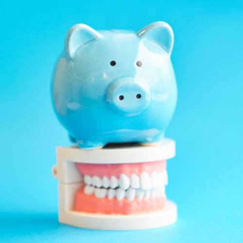 blue piggy bank sitting on a set of dentures in Minot 