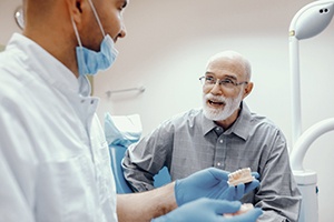 senior gentleman discussing the cost of dentures in Minot with his dentist 