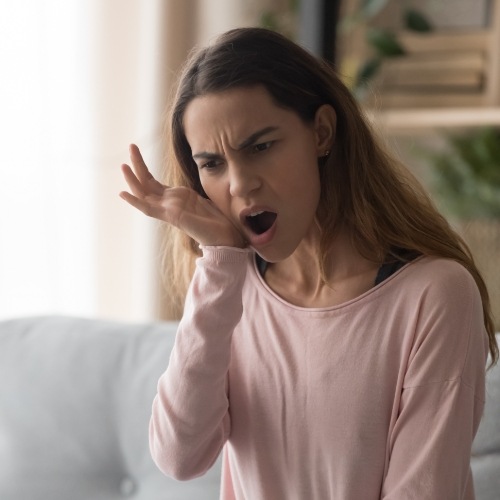 Woman who need emergency dentistry holding jaw