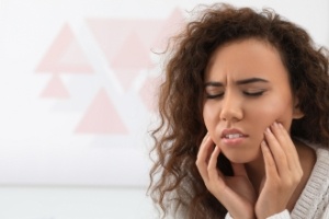 Woman with toothache holding cheek