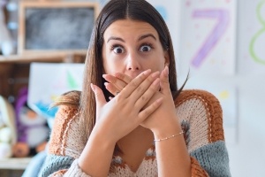 Woman with knocked out tooth covering her mouth