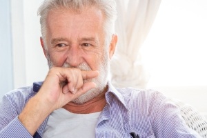 Man with lost filling cover his mouth