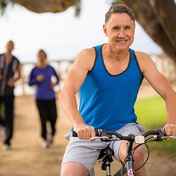 man smiling while riding a bike