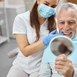 man smiling after getting dental implants in Minot