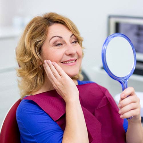 senior woman admiring her new smile with dental implants