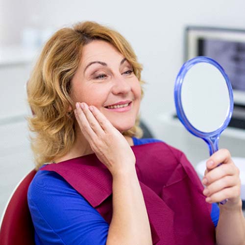 senior woman admiring her new smile with dental implants