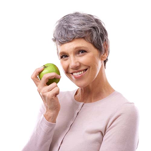 smiling woman holding a green apple 