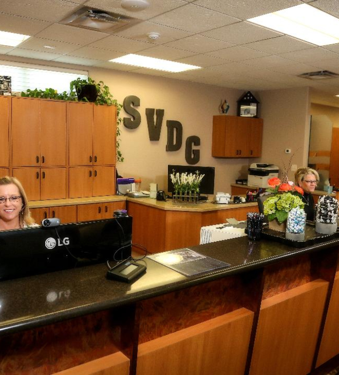 Two Minot dental team members at dental office front desk