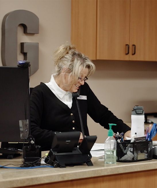 Dental team member talking on phone at front desk