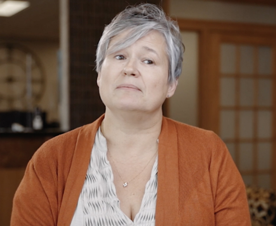 Woman in orange cardigan sitting in dental office