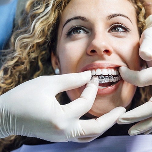 Dentist putting Invisalign aligner in patient's mouth