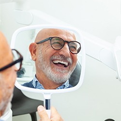 Man with black glasses smiling in reflecton