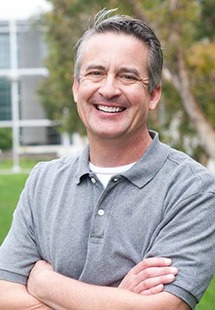 man smiling with arms crossed