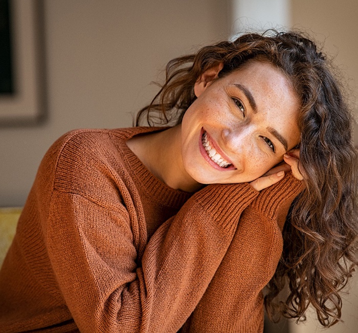 Woman smiling at home after a smile makeover in Minot, ND