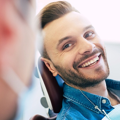 Man in denim jacket visiting a dentist for a smile makeover in Minot, ND