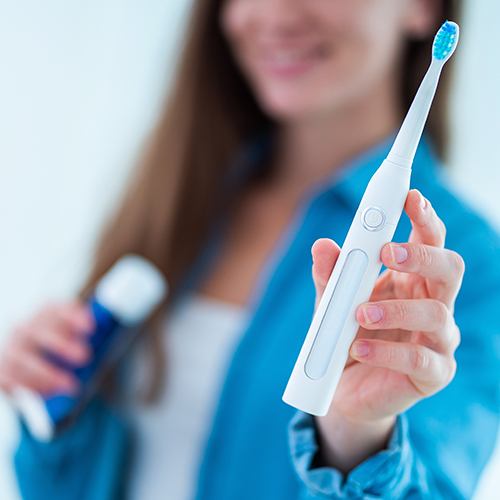 Smiling woman holding up a toothbrush