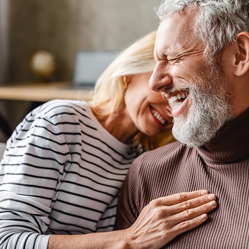 a couple smiling after undergoing root canal therapy