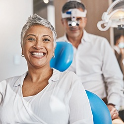 Woman smiling in treatment chair in front of dentist
