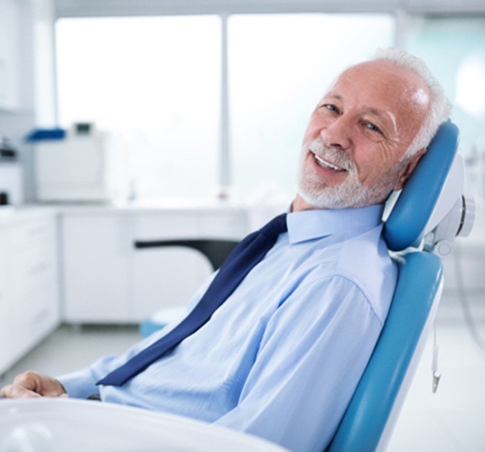 Senior man smiling after dental implant salvage in Minot, ND