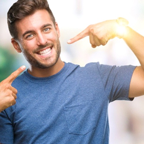 man pointing to his smile with veneers in Minot 