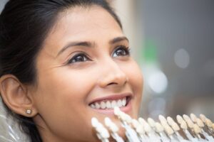Woman smiling with veneers in foreground.
