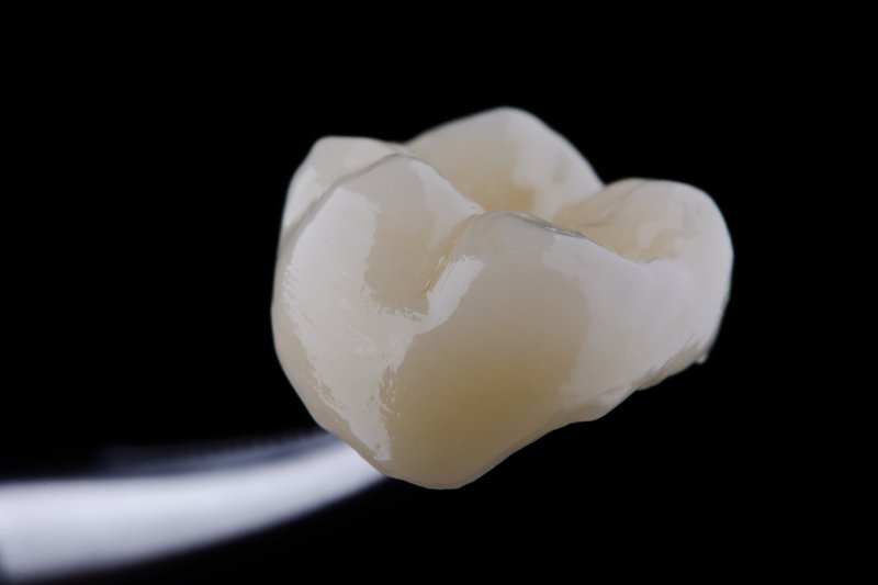 A high-quality dental crown set against a black background